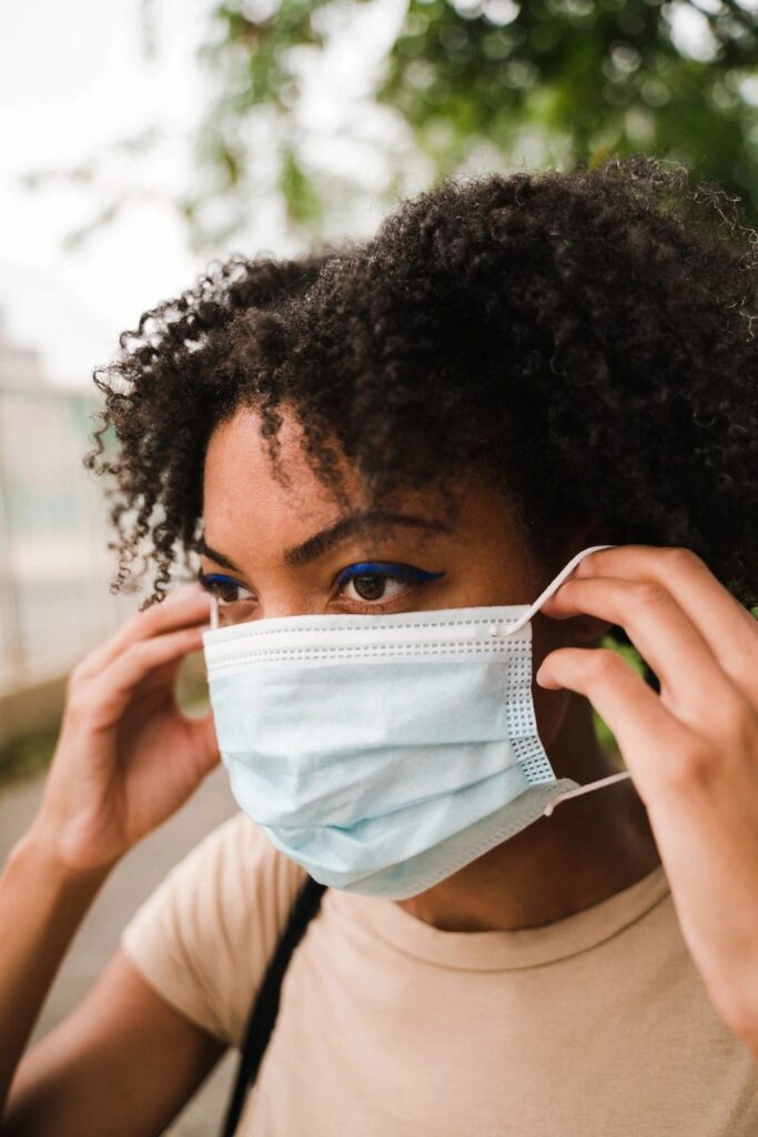 Woman putting on a disposable face mask